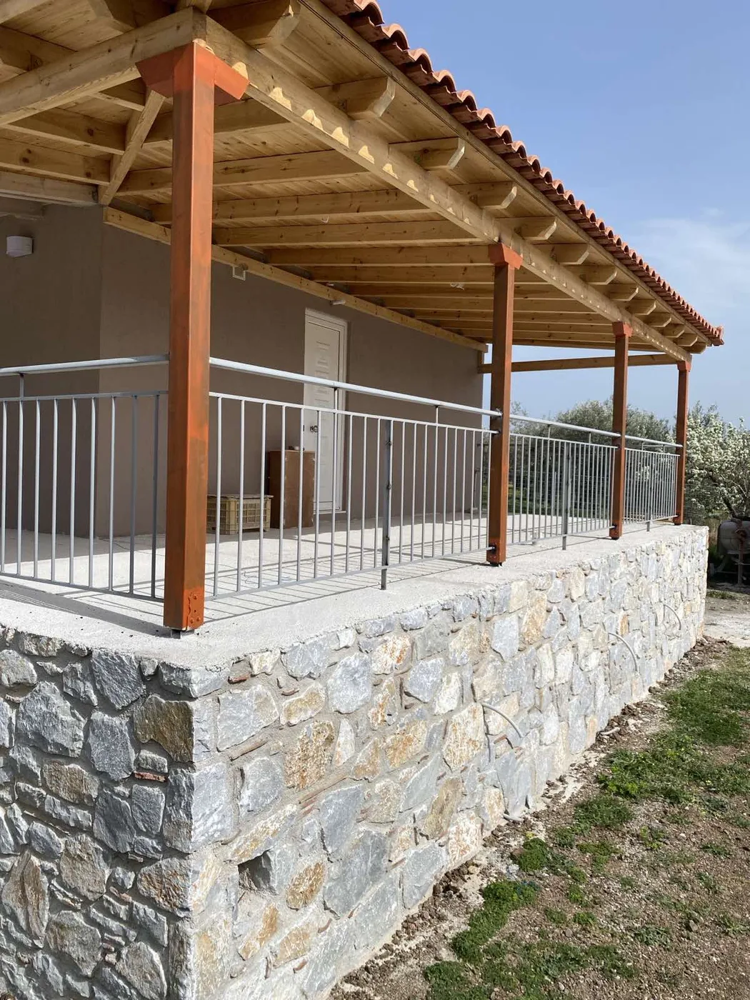 Ξύλινη πέργκολα με επένδυση πέτρας σε κατοικία